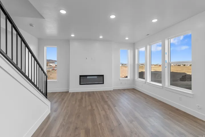 Wood-finish flooring throughout, complemented by recessed lighting and an integrated linear fireplace