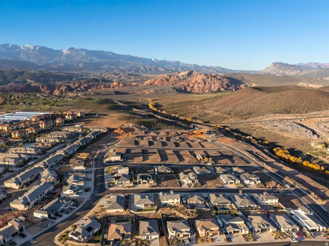 Expansive mountain scenery, developed residential streets, varied residential architecture, undeveloped plots, and distant townhomes