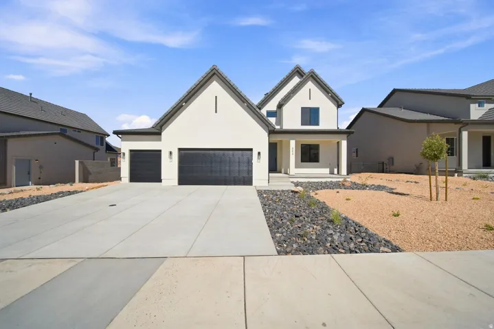 Contemporary exterior with a two-car garage, covered porch, and low-maintenance xeriscape landscaping