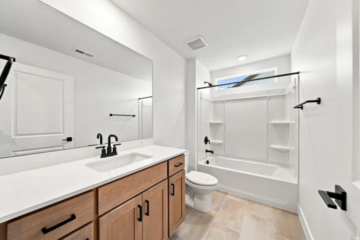 Bathroom featuring a single vanity with wood-finish cabinetry, a white countertop, and a rectangular undermount sink