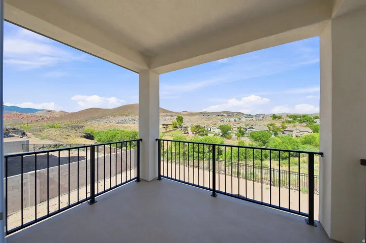 Covered balcony with concrete flooring and black metal railings