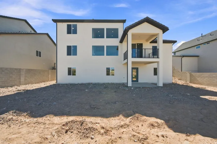 Multi-story stucco exterior with a covered balcony, an upper-level patio, and a ground-level patio