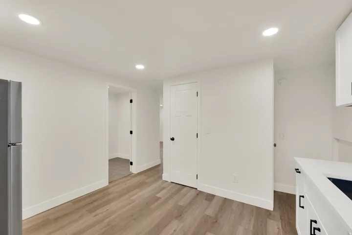 Recessed ceiling lighting illuminates wood-finish flooring