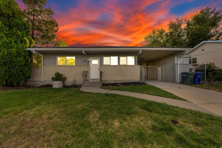 Ranch-style exterior with a covered entryway, brick facade, horizontal siding, and an attached carport
