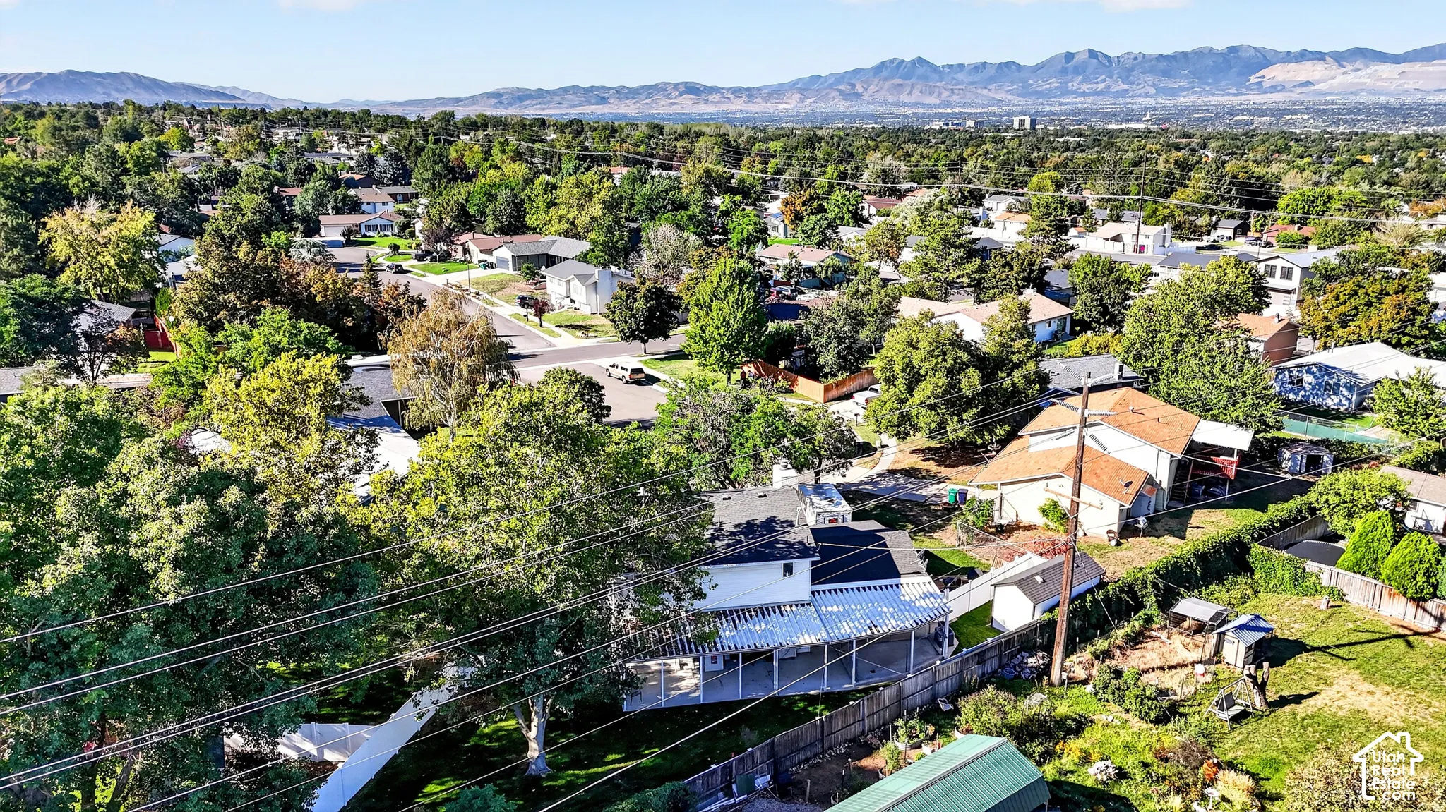 Residential neighborhood with mature trees and mountain backdrop