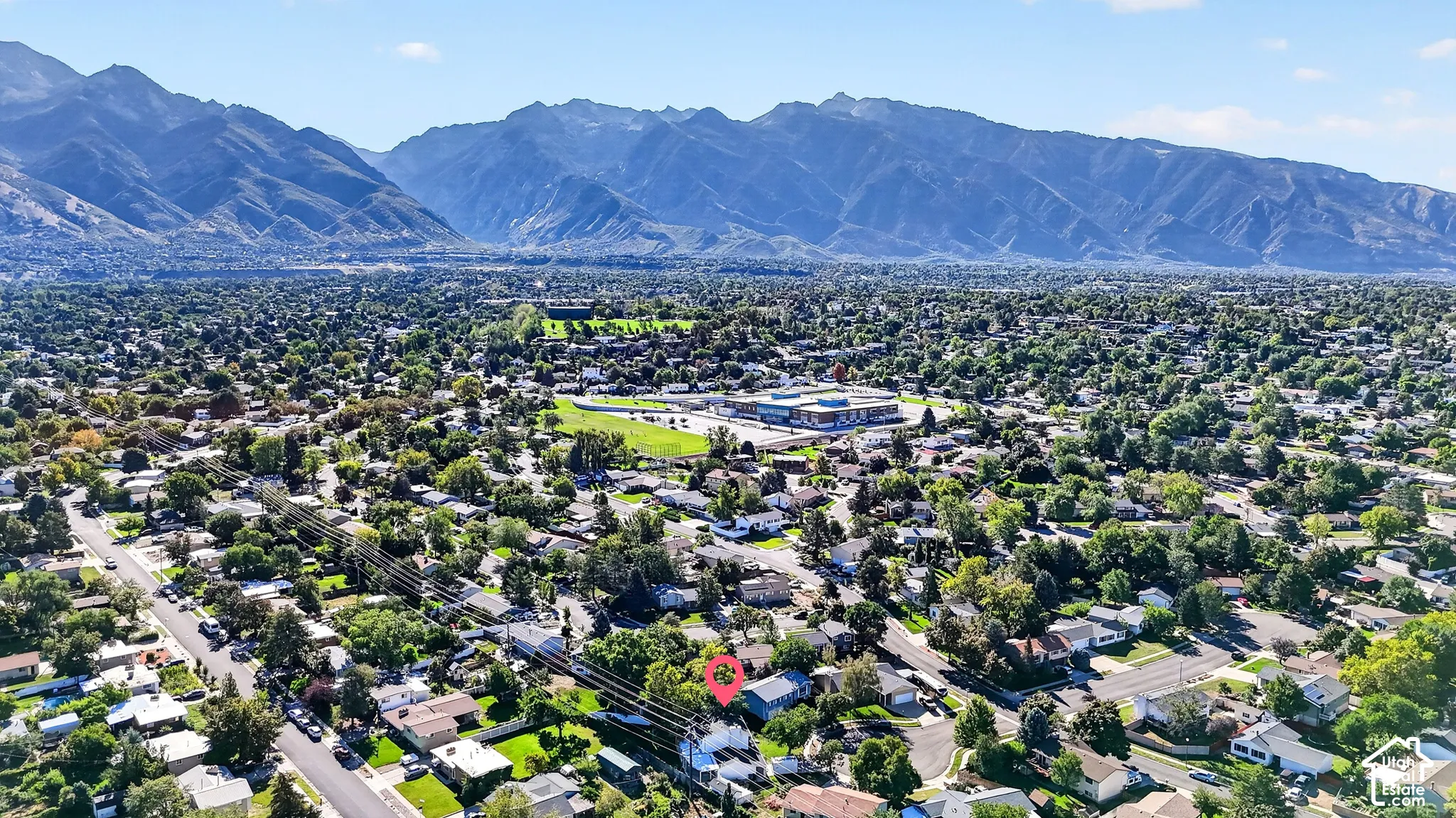 Residential neighborhood with mature trees and mountain backdrop