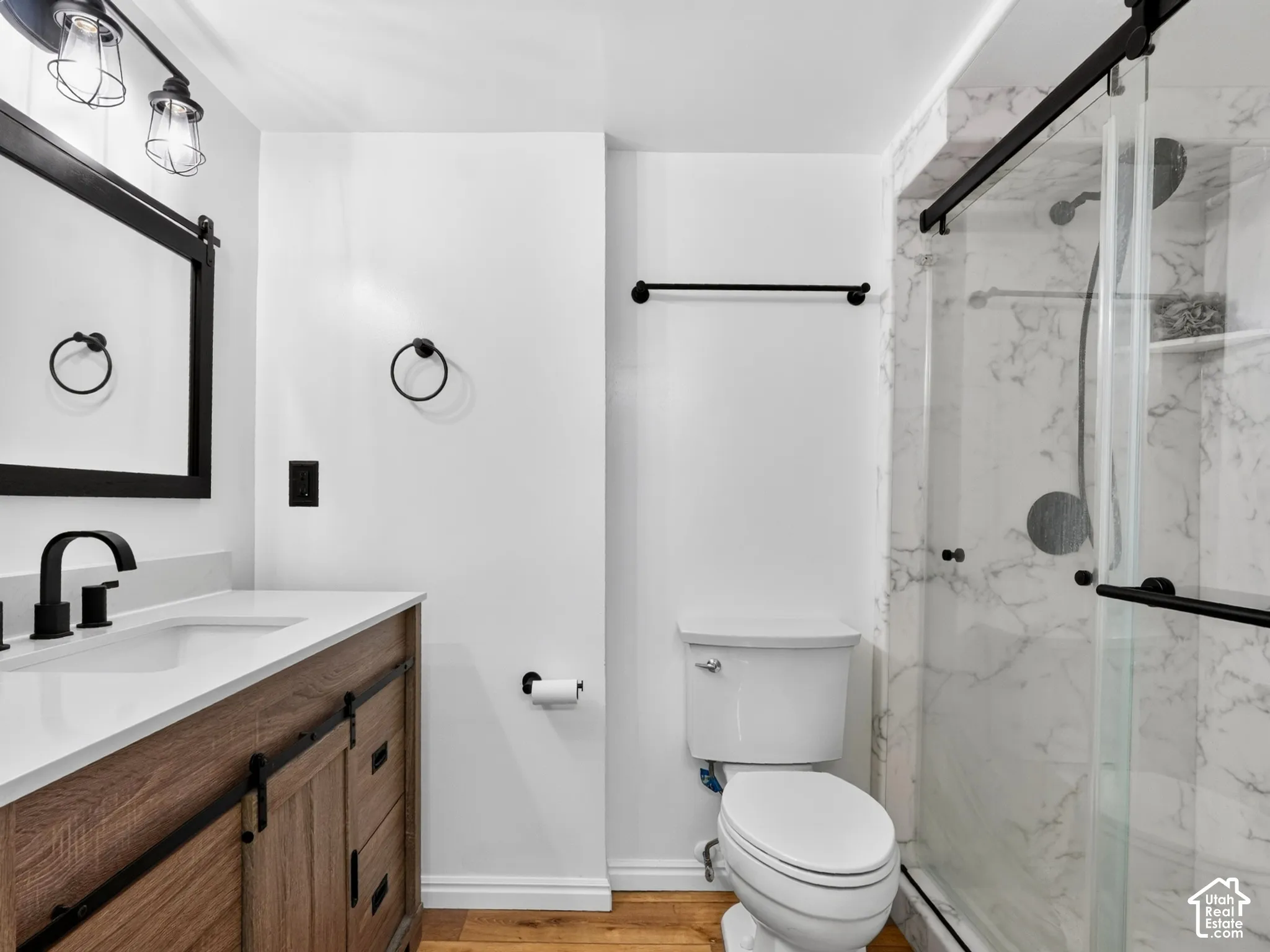 Wood-finish vanity with a white countertop and matte black fixtures