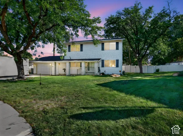 Two-story home with a light-colored exterior and dark shutters