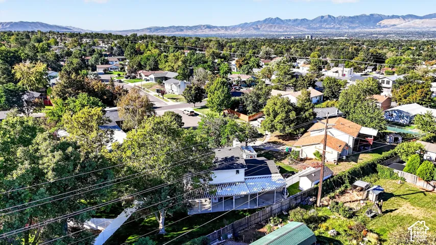 Residential neighborhood with mature trees and mountain backdrop
