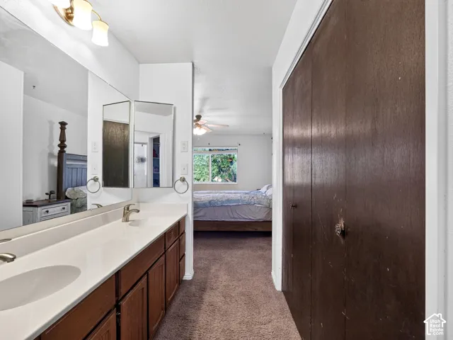 Double vanity with dual undermount sinks and individual mirrors, brushed nickel faucets, and a light fixture with three sconces