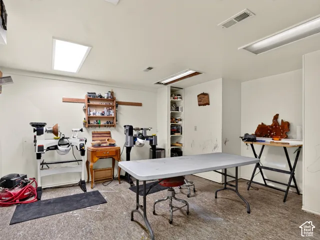 Expansive room featuring recessed lighting, ceiling-mounted fluorescent lighting, built-in shelving, and light-toned walls