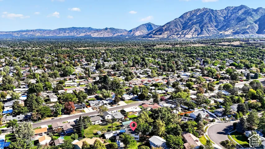 Residential neighborhood with mature trees and mountain backdrop