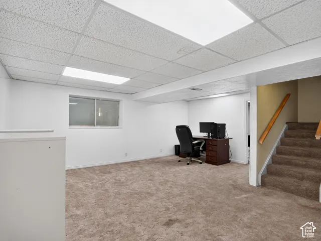 Carpeted flooring with white walls, a drop ceiling, and recessed lighting