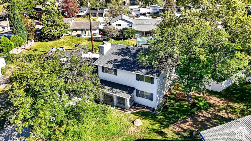 Two-story residence with white siding and dark shutters, featuring a covered porch