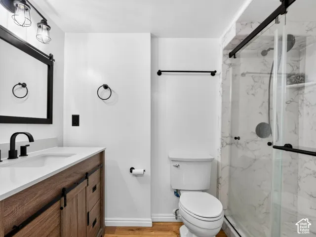 Wood-finish vanity with a white countertop and matte black fixtures