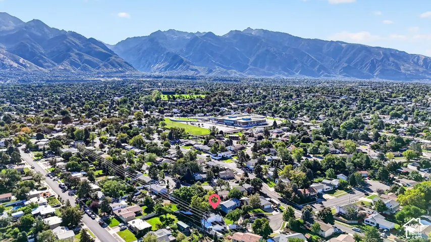 Residential neighborhood with mature trees and mountain backdrop
