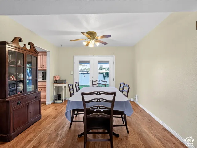 Wood-finish flooring throughout, ceiling fan with integrated lighting, and double glass-panel doors