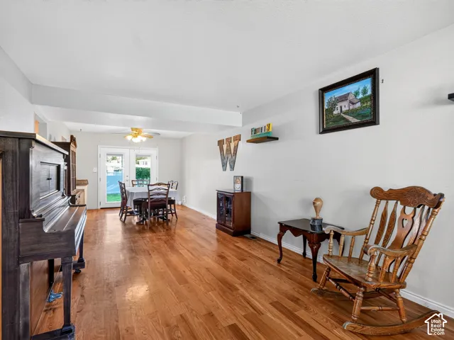 Wood-finish flooring throughout, white walls, and a ceiling fan in the dining area