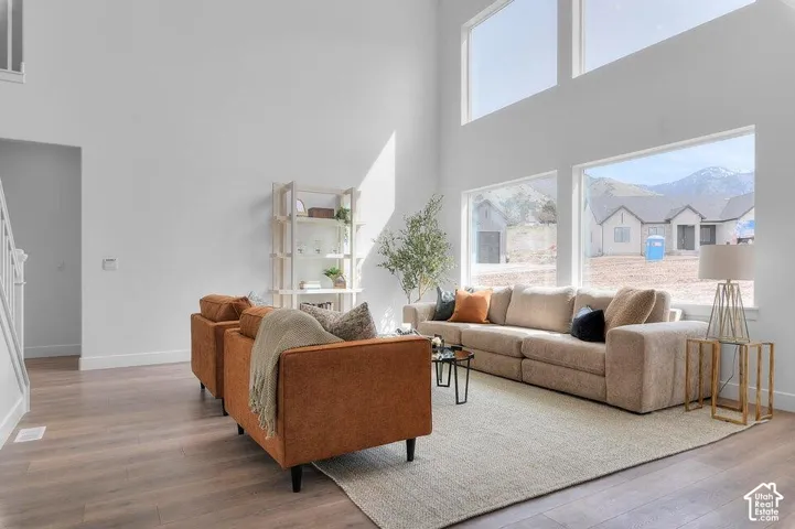 Two-story ceiling height with high-set windows, expansive picture windows, and wood-finish flooring