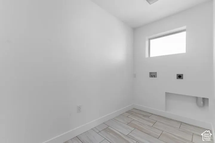 Laundry area featuring a window, tile flooring, and utility hookups