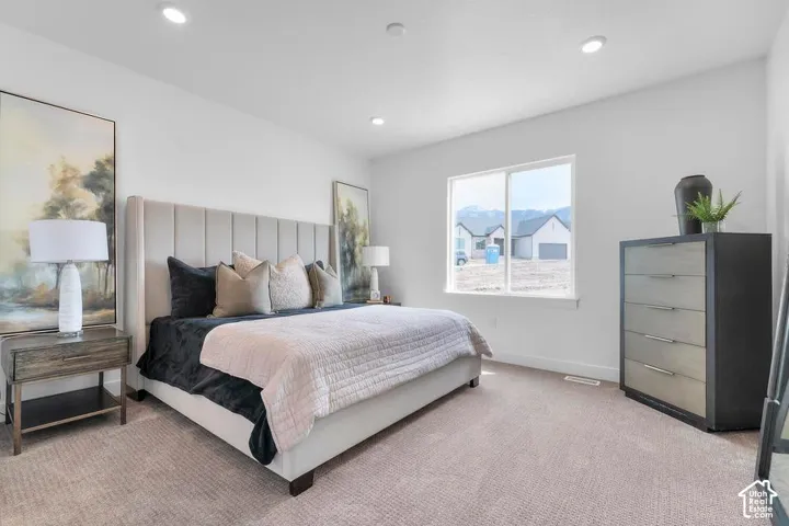 Spacious room featuring neutral carpeting, a large window, and recessed ceiling lighting