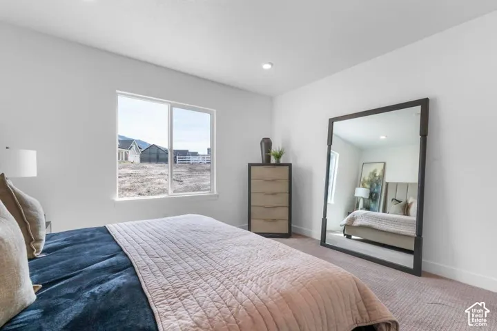 Recessed ceiling lighting, light neutral wall paint, white window trim, and carpeted flooring