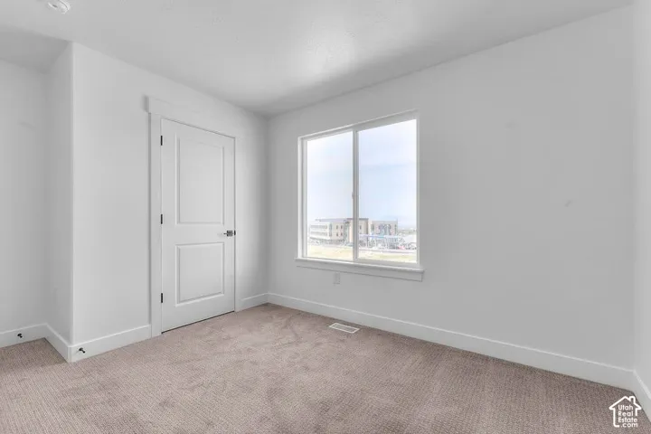 Neutral wall paint, carpet flooring, and a multi-pane window