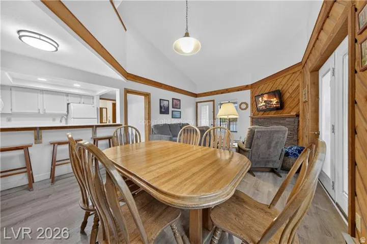Dining area featuring a wood-finish table with matching chairs, wood-trimmed architectural elements throughout, and pendant lighting