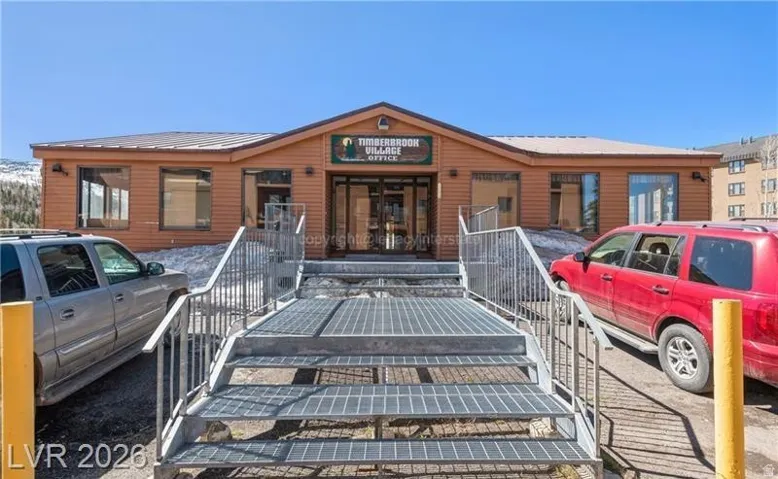 Building with wood-look siding, multiple windows, and a prominent entry