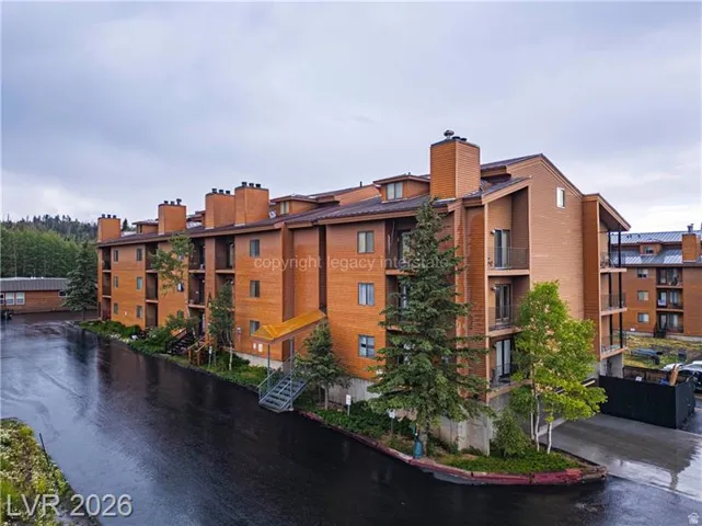 Multi-story building featuring brick and wood-finish siding, multiple balconies, and multiple chimneys