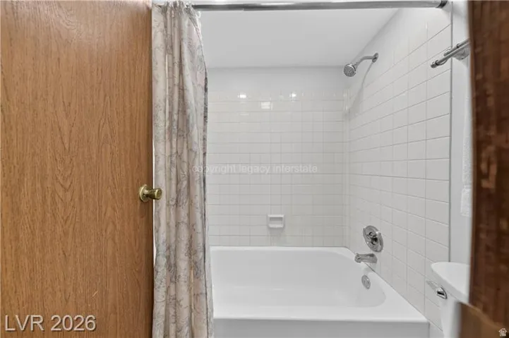 White subway tile shower surround with integrated soap dish, showerhead with chrome finish, and chrome bathtub faucet