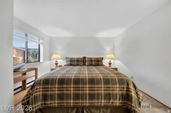 White painted walls, wood-finish flooring, window with blinds, and white ceiling