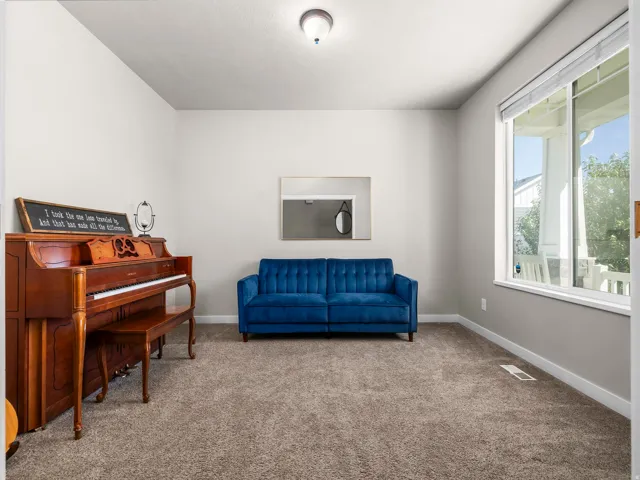 Plush carpet flooring, neutral paint tones, recessed lighting, and a large window providing natural light