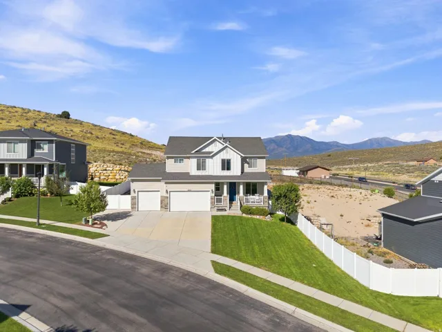 Two-story residence with a two-car garage, front porch, and manicured lawn