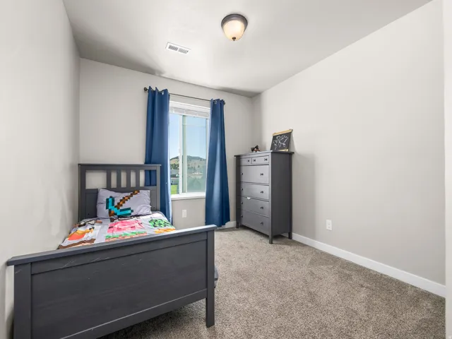 Recessed window with exterior scenery, overhead flush mount light fixture, textured carpeting, and neutral wall tones