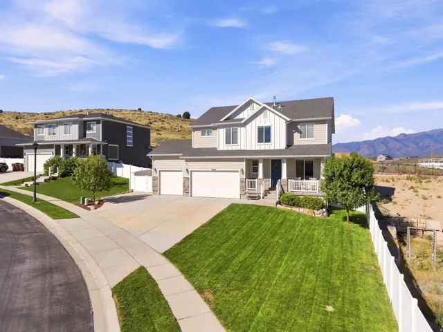 Two-story residence with a two-car garage, front porch, and sloped lawn