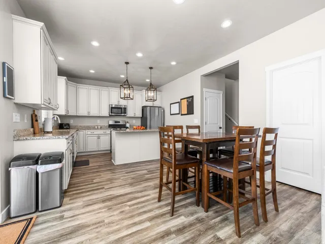Kitchen featuring wood-finish flooring, white cabinetry, a kitchen island, and recessed lighting