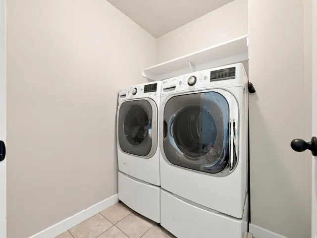 Laundry area featuring a built-in shelf and tile flooring