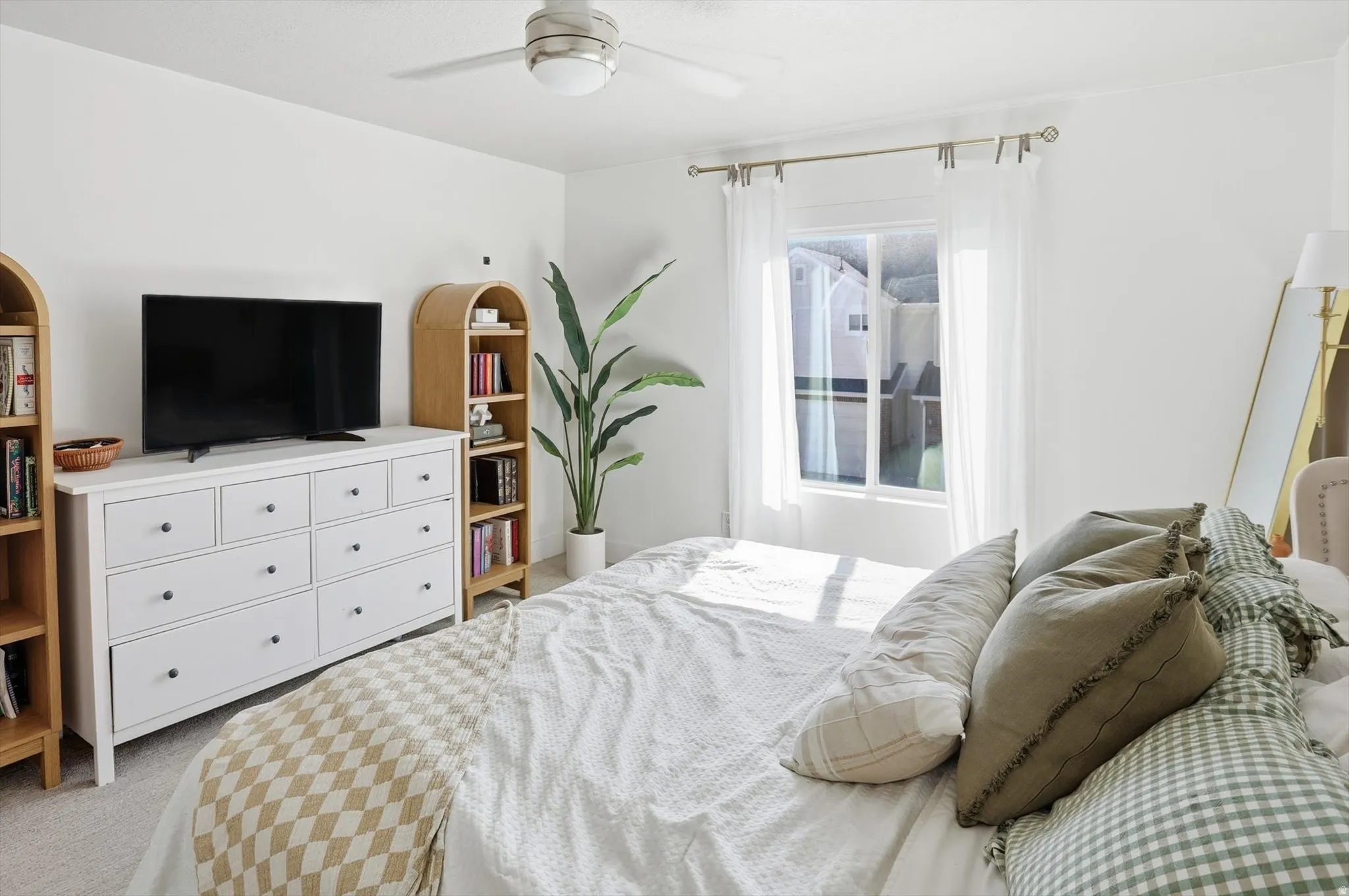 White walls and ceiling, ceiling fan with light fixture, window with drapes, and carpeted flooring