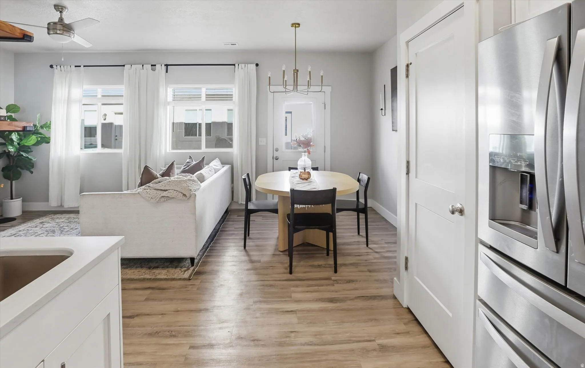 Open-concept living space featuring wood-finish flooring, recessed lighting, and a brushed nickel ceiling fan