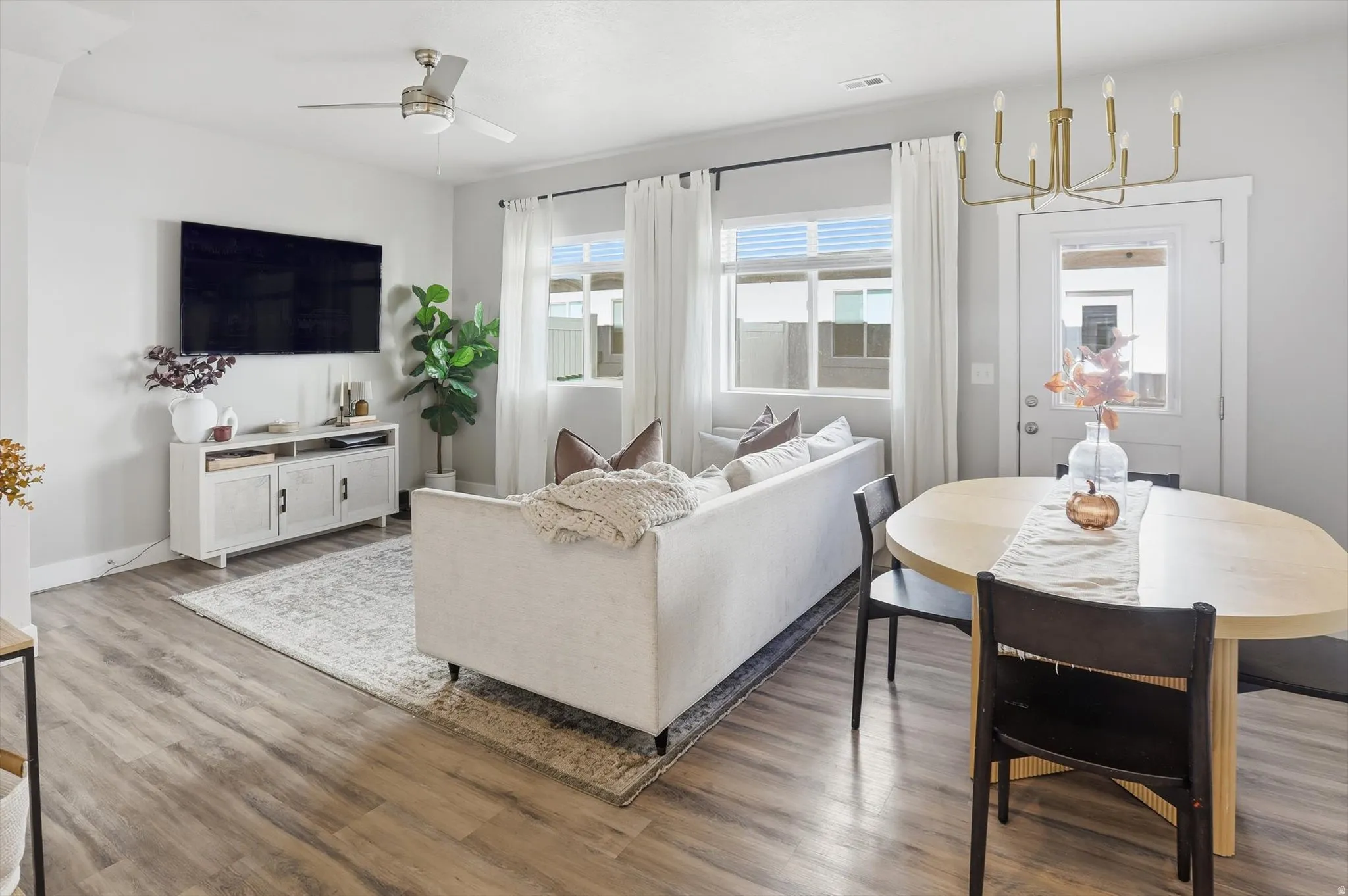 Wood-finish flooring, recessed lighting, and a ceiling fan with integrated light