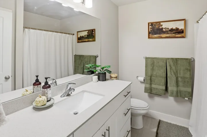 White vanity with brushed nickel hardware, integrated rectangular sink, and light-toned countertop