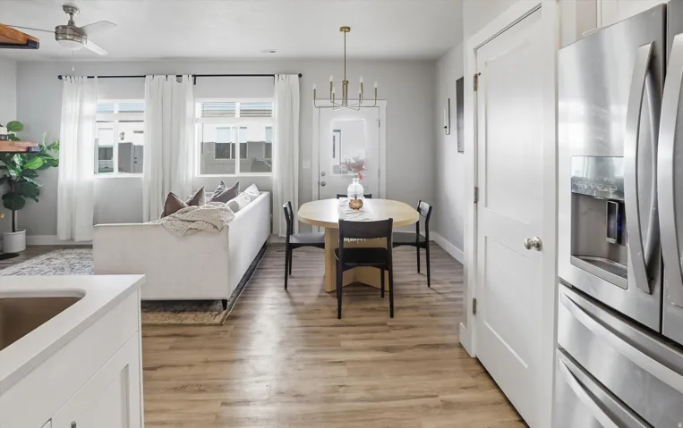 Open-concept living space featuring wood-finish flooring, recessed lighting, and a brushed nickel ceiling fan