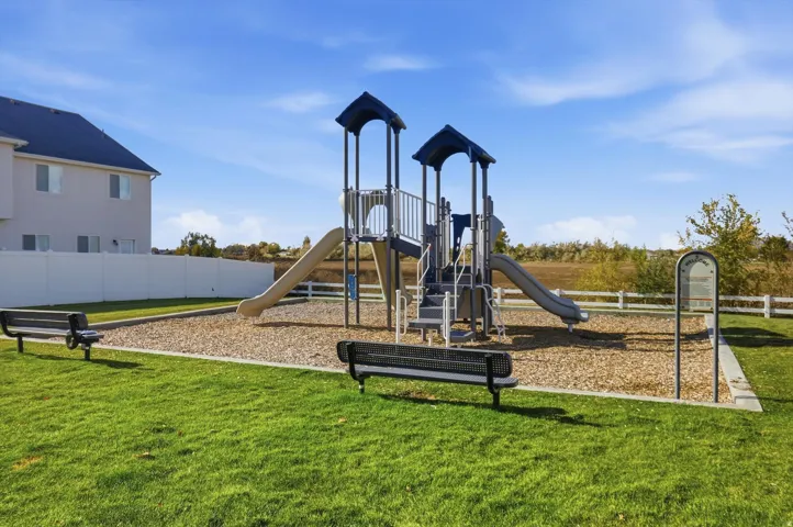 Community playground with two slides, benches, and wood chip surfacing