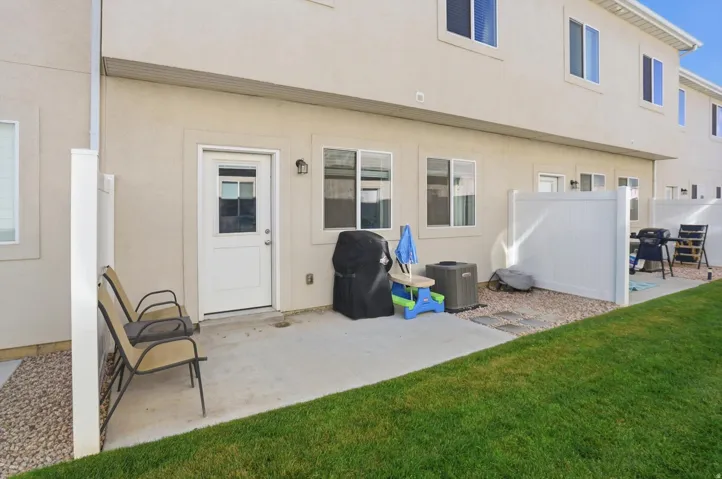 Private patio with concrete surfacing, adjacent to a manicured lawn area