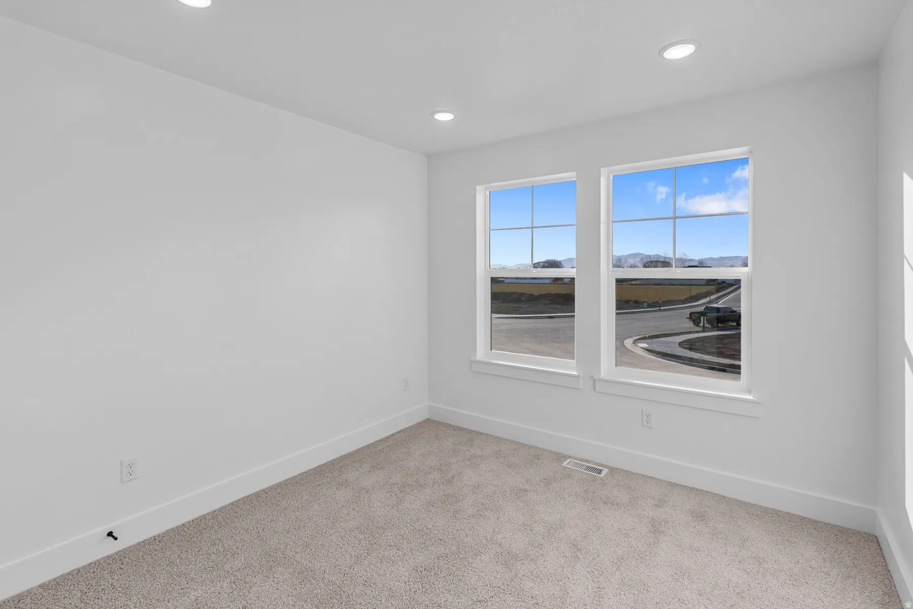 Recessed lighting illuminates the space, featuring two large windows with grid patterns