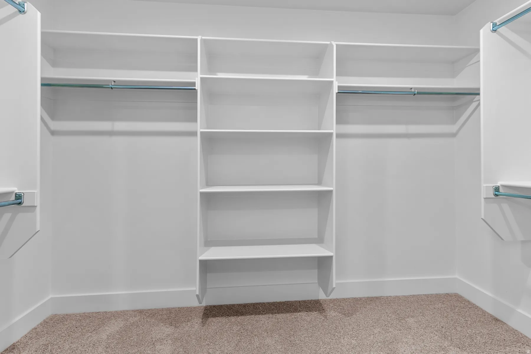 Built-in closet system featuring multiple shelves, hanging rods, and carpet flooring