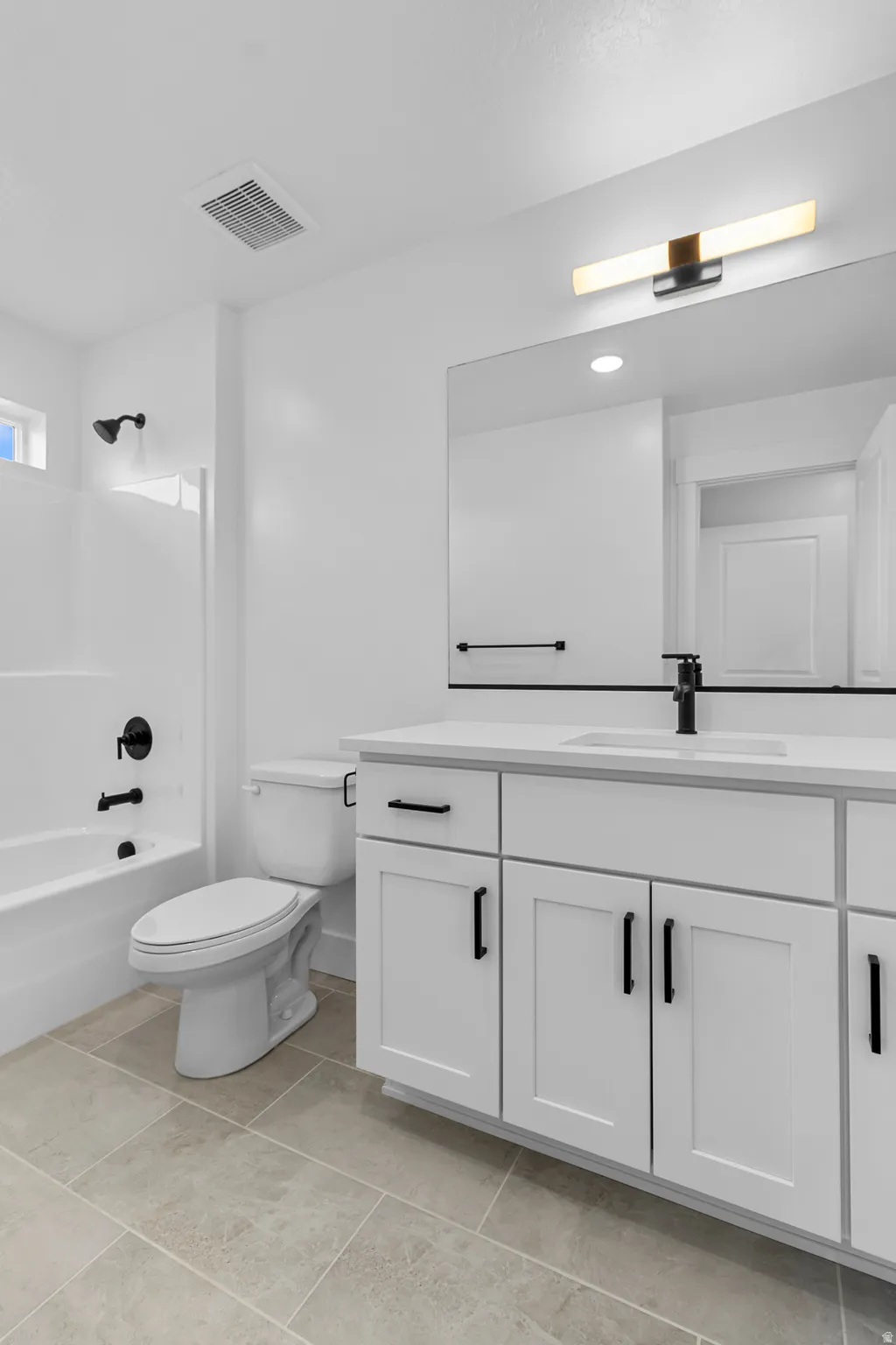White vanity with black hardware, white countertop, and integrated sink