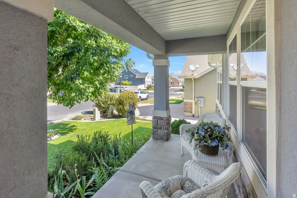 Covered front porch with concrete flooring and stucco exterior