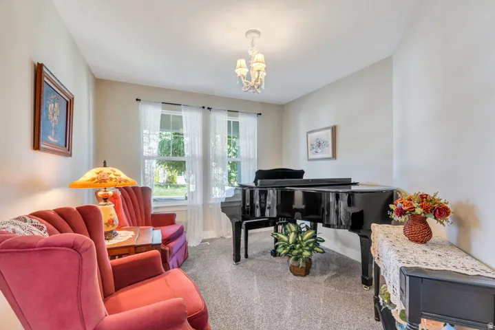 Wall-to-wall carpeting with neutral wall tones and a chandelier light fixture